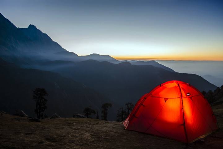 Lit up tent overlooking mountains